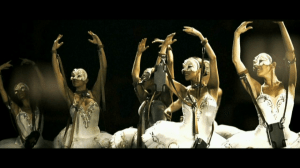 Five ballerinas wearing ballet dresses with their hands curved upward